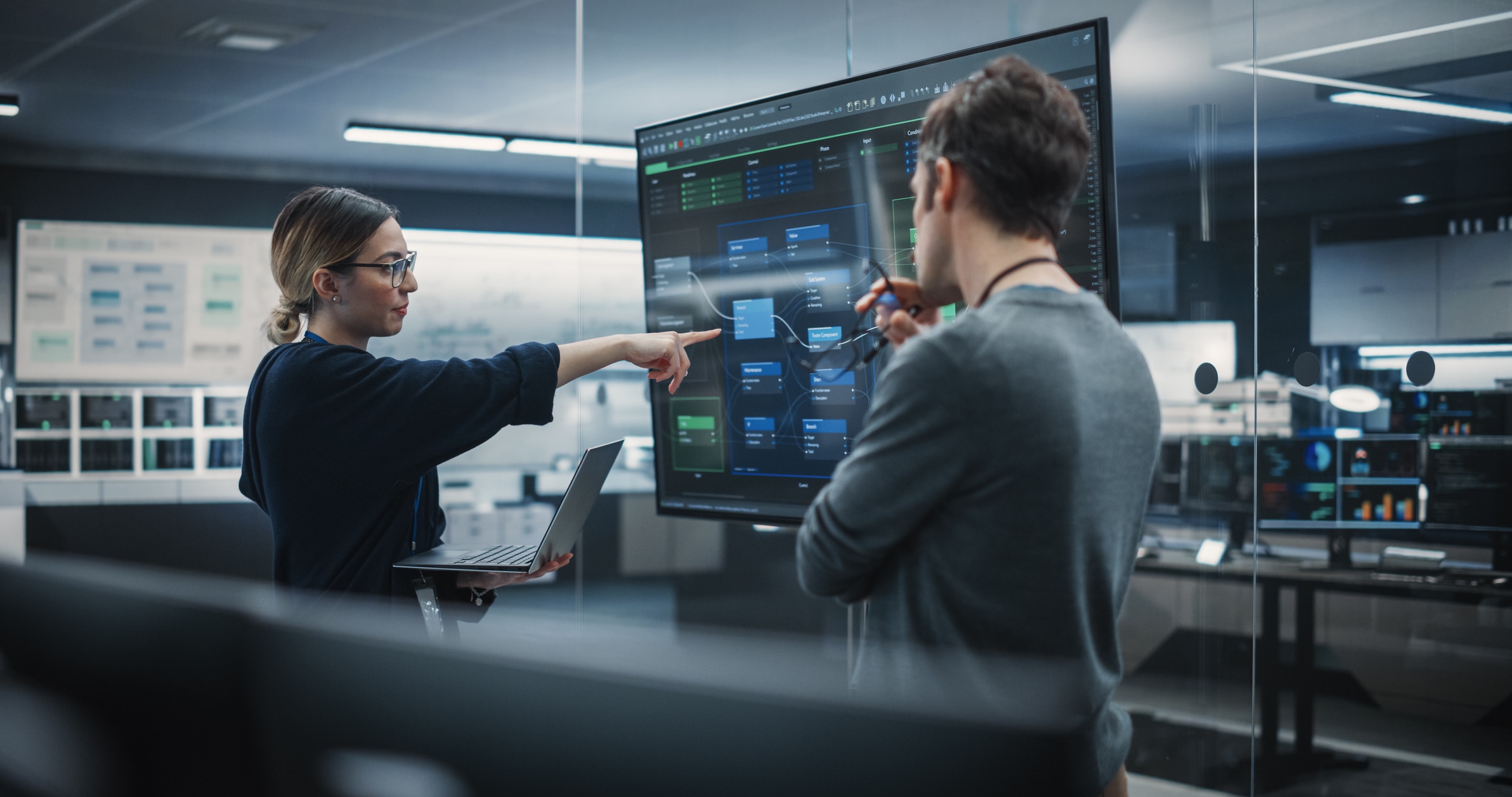 Two Diverse Software Developers Having a Meeting in a Conference Room