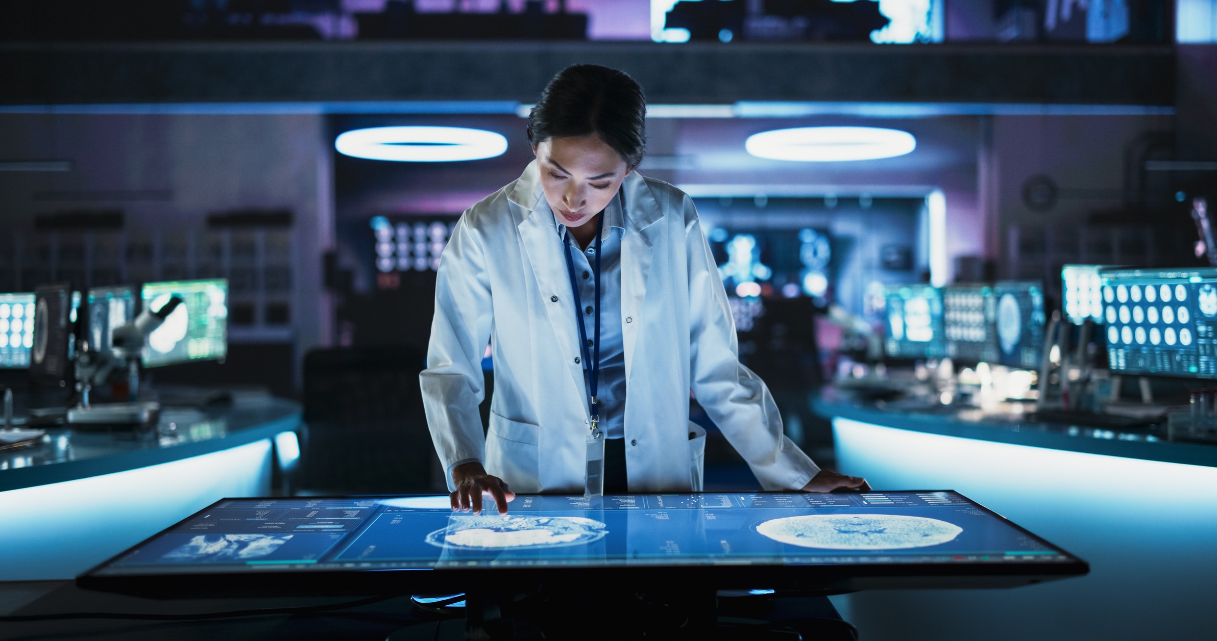 Female Asian Neuroscinetist Using Interactive Touch Screen Table With MRI Scans